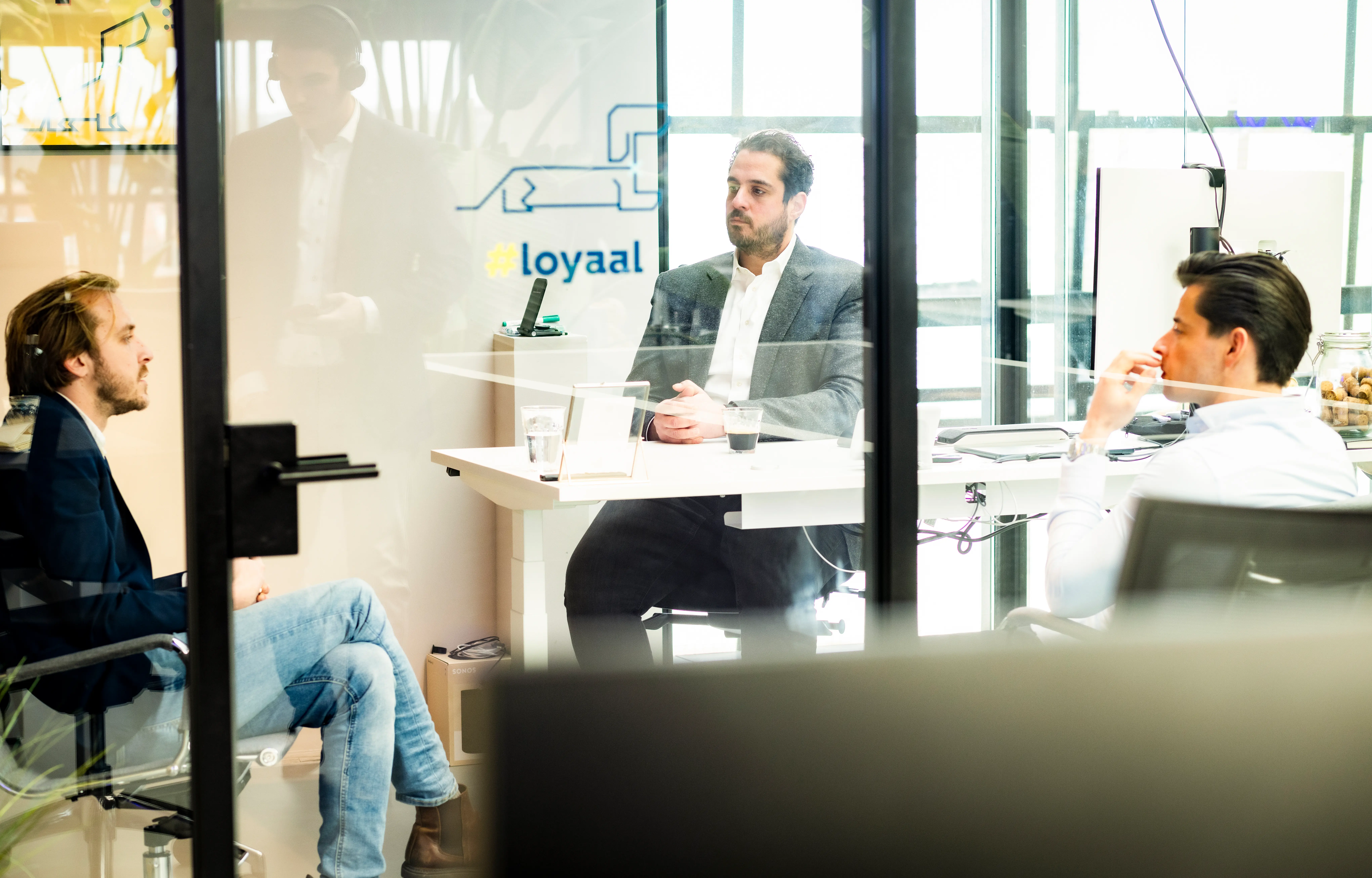 Drie mensen in een vergaderruimte, bezig met een bespreking over IT-recruitment en de inzet van AI in het wervingsproces