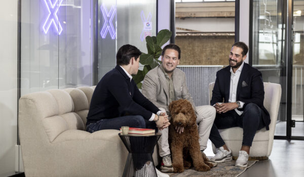 AI engineers in gesprek op een grijze bank in een kantoorgebouw