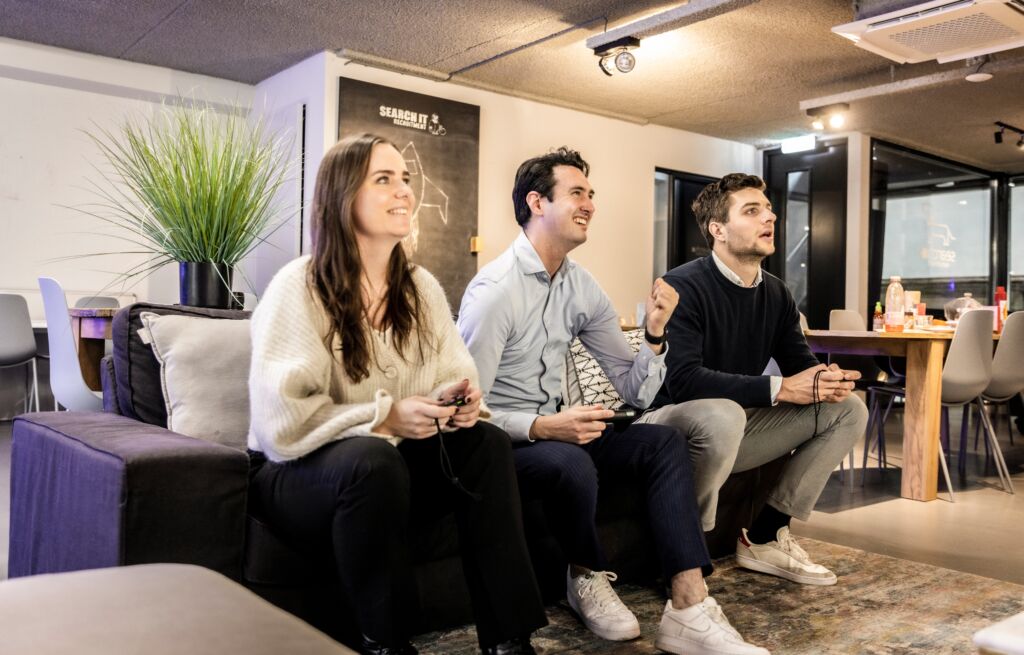werknemers op de bank die een spel spelen in de kantine van het kantoor. Wat willen werknemers écht? 5 verrassende inzichten uit recent onderzoek naar arbeidsvoorwaarden