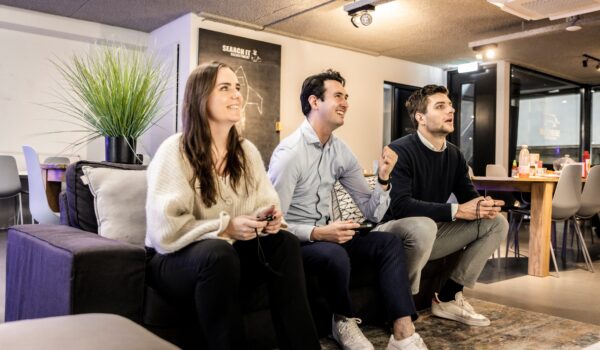 werknemers op de bank die een spel spelen in de kantine van het kantoor. Wat willen werknemers écht? 5 verrassende inzichten uit recent onderzoek naar arbeidsvoorwaarden